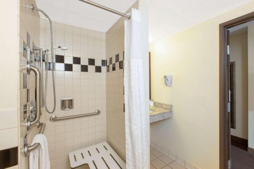 a bathroom with a shower with a toilet at AmericInn by Wyndham Ottumwa in Ottumwa