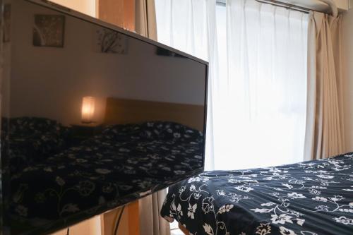 a mirror reflection of a bed in a bedroom at Fukuoka Condominium in Fukuoka