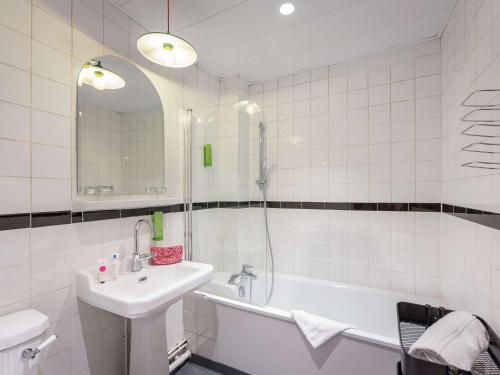 La salle de bains blanche est pourvue d'un lavabo et d'une baignoire. dans l'établissement greet Marseille Centre Saint Charles, à Marseille