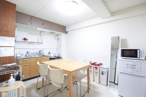 a kitchen with a wooden table and white appliances at Fukuoka Condominium in Fukuoka
