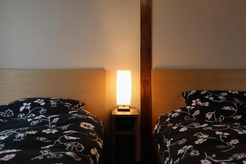 a bedroom with a bed and a lamp on a night stand at Fukuoka Condominium in Fukuoka