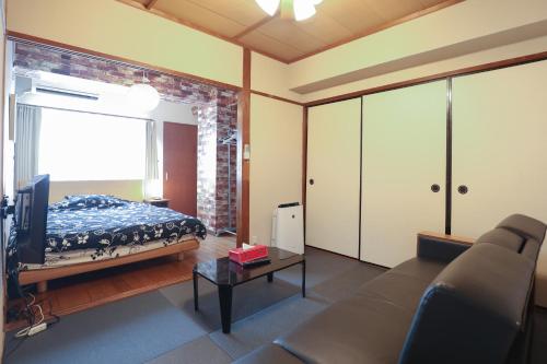 a living room with a bed and a couch at Fukuoka Condominium in Fukuoka