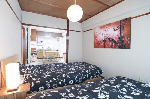 a bedroom with a bed and a painting on the wall at Fukuoka Condominium in Fukuoka