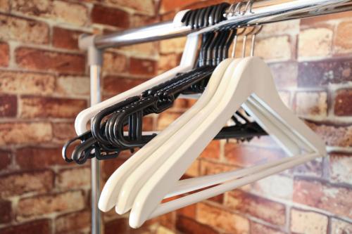 a rack with white chairs hanging from a brick wall at Fukuoka Condominium in Fukuoka