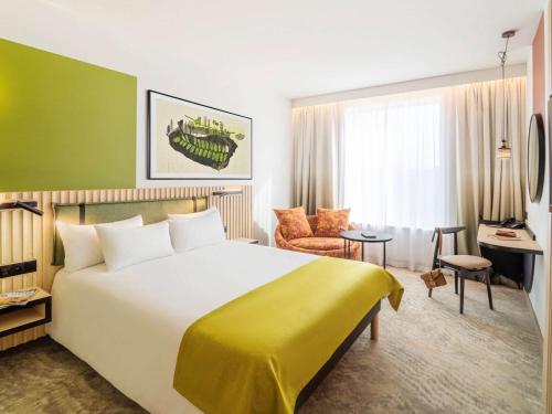 een hotelkamer met een groot bed en een bureau bij Mercure Katowice Centrum in Katowice