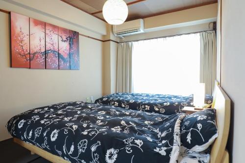 a bedroom with a bed and a window at Fukuoka Condominium in Fukuoka