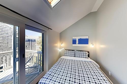 um pequeno quarto com uma cama e uma varanda em Long Pier Lodge em Provincetown