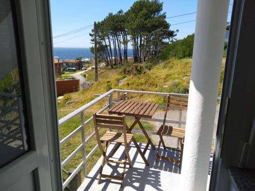 d'une table et de chaises sur un balcon avec vue sur l'océan. dans l'établissement Apartamento Peregrinos Por la Costa Camino Portugués As Casetas, à Rosal
