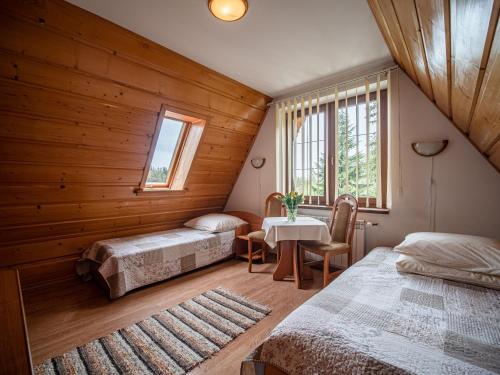 Un dormitorio con dos camas y una mesa y una ventana. en Willa U Zająców I, en Zakopane