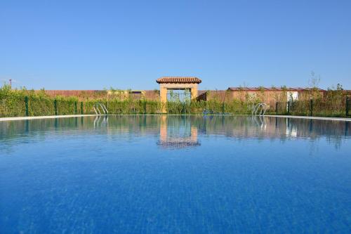 a large pool of blue water with a building in the background at Hotel San Miguel del Valle Amblés in El Fresno