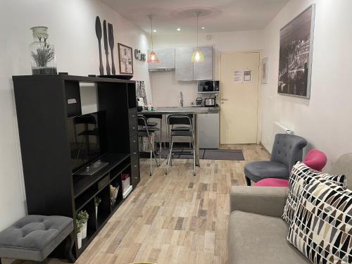 a living room with a couch and a kitchen at Bel appartement au cœur de paris in Paris