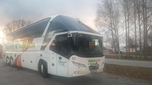 a white bus is driving down a street at SJÖTORPS HOSTEL in Sjötorp