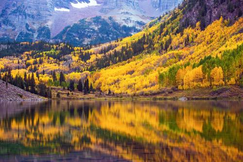 a lake in the mountains with autumn colours at Gore Creek Getaway in Vail