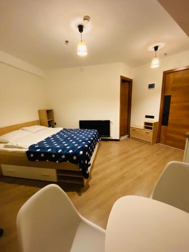 a bedroom with a bed and a tv and chairs at Marshall Apartment 202 in Gudauri