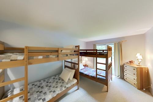 a room with two bunk beds and a desk at Adventure Basecamp in Stowe