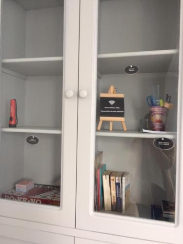 a white cupboard with books in it at La Péninsule Town Apartment No 5 in Curepipe