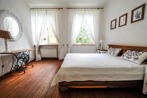a bedroom with a large bed and two windows at Castle Square Apartment in Warsaw