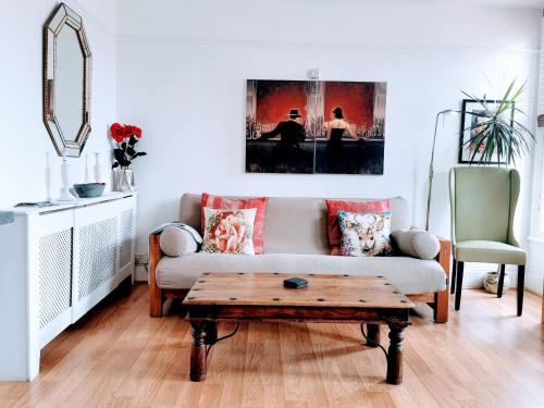 a living room with a couch and a coffee table at Victoriana Apartment - Private Balcony in Stratford-upon-Avon