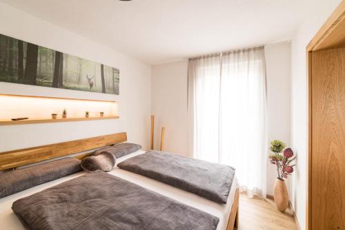 a bedroom with two beds and a window at Alpen-Lounge Apartment 17 in Fügen