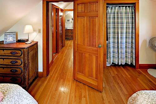 a bedroom with a wooden door and a wooden floor at Areys Pond Point in Orleans
