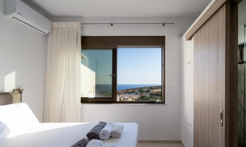 a bedroom with a window with a view of the ocean at Agia Pelagia Villas in Agia Pelagia