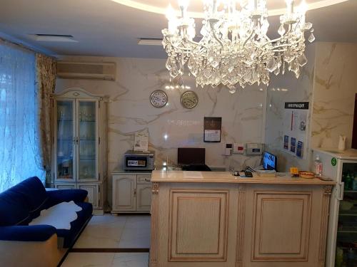 a living room with a chandelier and a kitchen at Happy Inn Sofiyskaya in Saint Petersburg