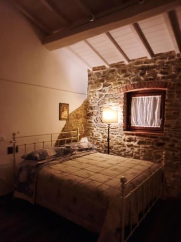 a bedroom with a bed in a stone wall at Ca' delle Sore in Arezzo