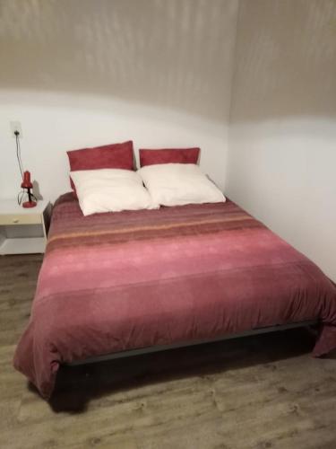 un lit avec deux oreillers dessus dans une chambre dans l'établissement Studio meublé Viane, à Viane