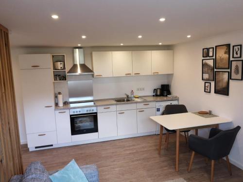 a kitchen with white cabinets and a table at Ferienwohnung Hofmeier in Hinterzarten