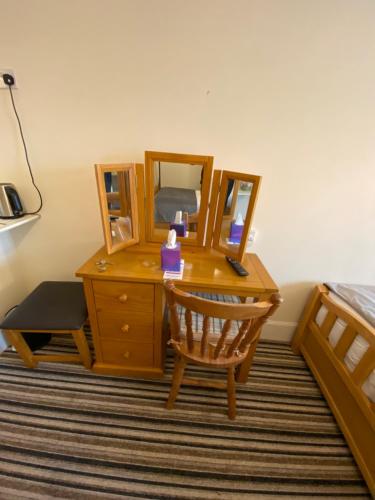 a bedroom with a desk with a bed and a mirror at Four Seasons Guest House in Canterbury