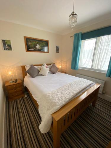 a bedroom with a large bed with blue curtains at Four Seasons Guest House in Canterbury