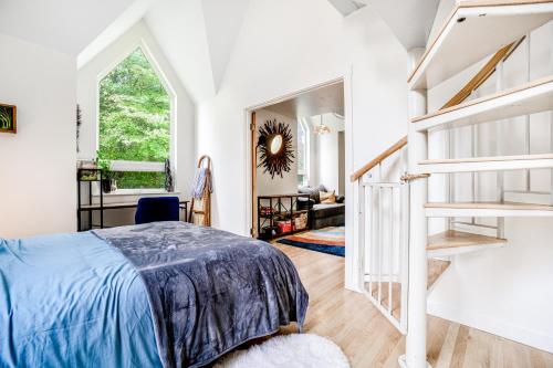 a white bedroom with a bed and a staircase at Enchanted Cottage in Vashon