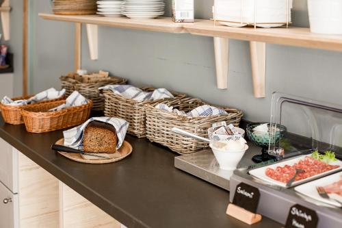 a counter with baskets of bread and other foods at Duvan Hotell & Konferens in Uppsala