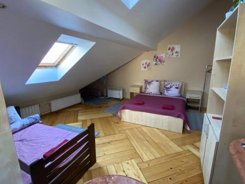 a attic bedroom with two beds and a window at Вілла Графа in Lviv