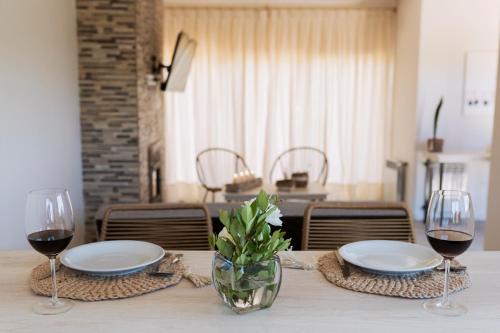 波特雷里約斯的住宿－El Castaño Apart，一张桌子,上面放着两杯红葡萄酒和盘子
