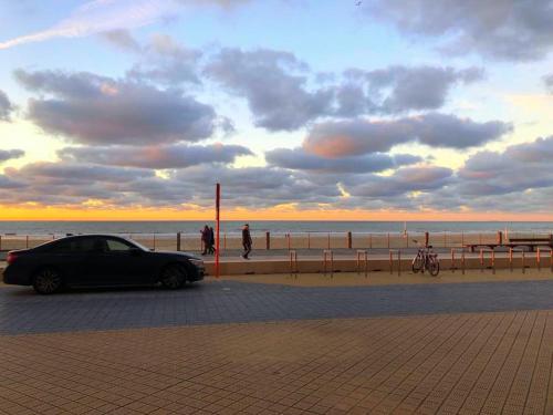 a car parked next to the beach with the ocean at You, me and the sea - seaview groundfloor appartment in Ostend