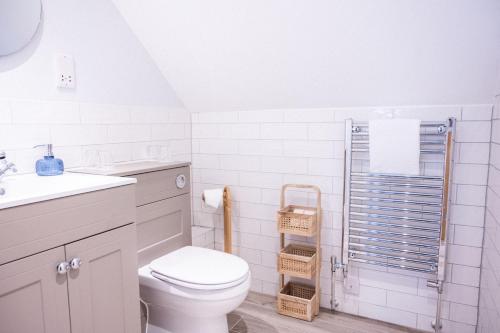 a white bathroom with a toilet and a sink at The Kingswood Hotel in Sidmouth