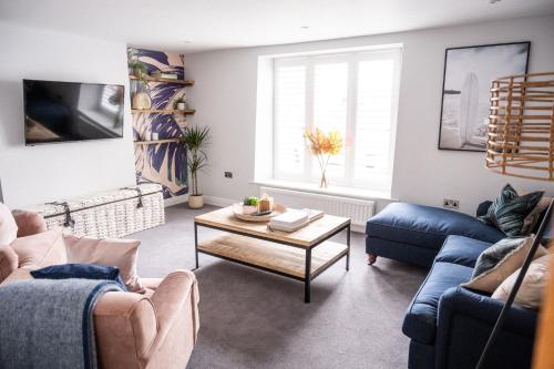 a living room with two blue couches and a table at The Kingswood Hotel in Sidmouth