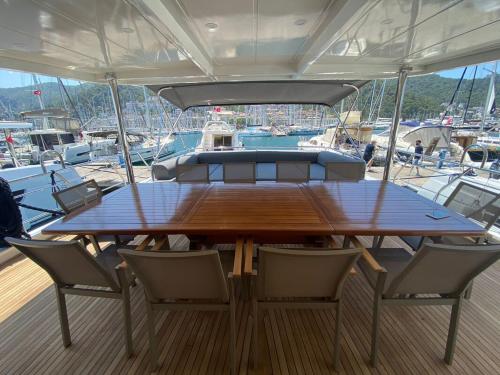 a wooden table and chairs on a boat at Yacht Room Hotel in Fethiye