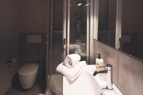 a bathroom with a sink and a toilet and a mirror at Landart Hotel in Sittensen