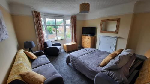 1 dormitorio con cama, sofá y TV en "Near to the Beach "- 2 bedroom Flat Sleeps up to 5, en Burnham-on-Sea