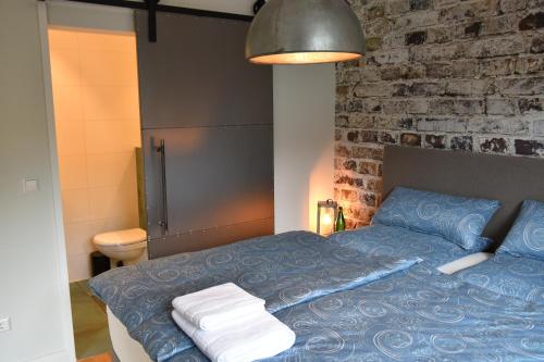a bedroom with a blue bed and a brick wall at Annettes Pfalz in Hinterweidenthal