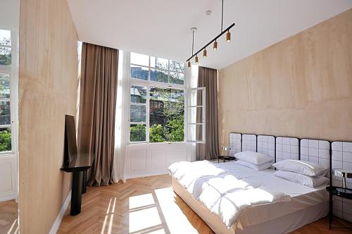 a bedroom with a bed and a large window at The 10 in Tbilisi City