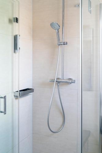 a shower with a shower head in a bathroom at City Hotel Bosse in Bad Oeynhausen