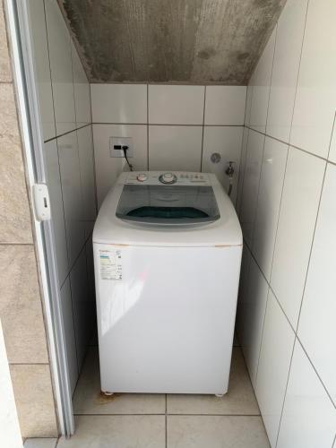 a washer and dryer in a tiled bathroom at Apto em Laguna a 10 min praia do Mar Grosso - 106 in Laguna
