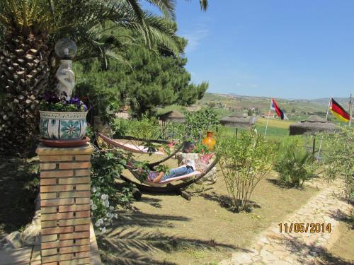 two people laying in hammocks in a garden at Agriturismo Reggia Saracena in Agrigento