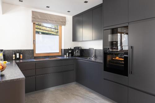 a kitchen with gray cabinets and an oven at Ferienlodge Edelstein in Forstau