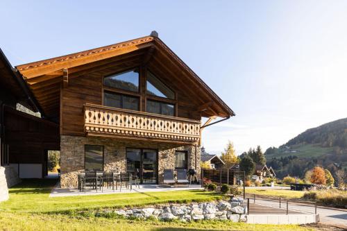 a log house with a balcony on the side of it at Ferienlodge Edelstein in Forstau