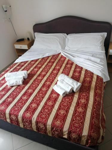a bed with two white towels on top of it at Hotel Riposo in Gatteo a Mare