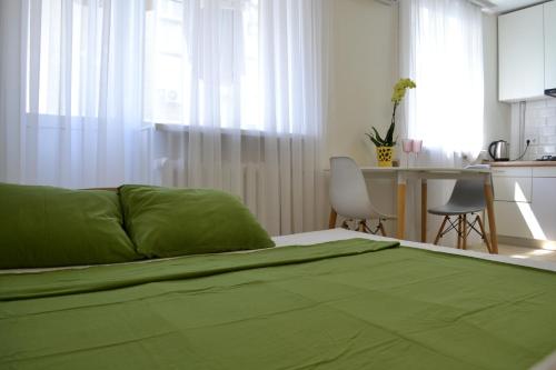 - une chambre avec un lit vert et une table dans l'établissement Honey Bunny, à Krementchouk